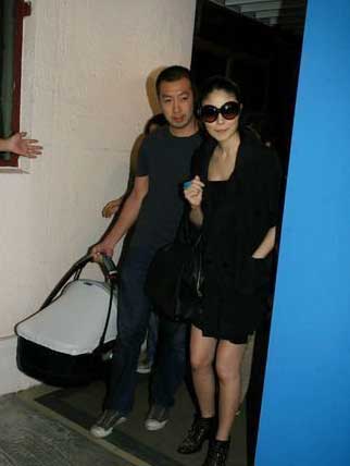 Kelly Chen (L) and husband Alex Lau walk out of a hospital in Hong Kong on Wendesday, July 15, 2009.