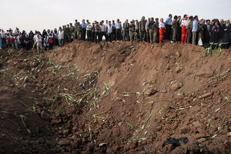 Relatives of passengers on board the crashed Tupolev Caspian airplane mourn at the crash site in Qazvin, northwestern Iran, July 16, 2009. Two badly damaged black box recorders have been recovered from the Tupolev Caspian Airlines aircraft that crashed in Iran on Wednesday, killing all 168 people on board, official media reported on Thursday. [Ahmad Halabisaz/Xinhua]