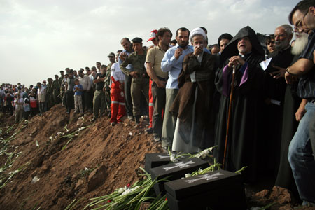 Iran-based Armenian Church Archbishop Sebuh Sarkissian (3rd R) hosts a religious ritual to mourn for the victims near the crater left by the crashed airplane in Qazvin, northwestern Iran, July 16, 2009. [Ahmad Halabisaz/Xinhua] 