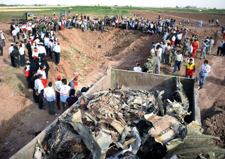 Relatives of the victims of the crashed Tupolev Tu-154 passenger plane mourn around the crater left by the crashed airplane in Qazvin, northwestern Iran, July 16, 2009. [Ahmad Halabisaz/Xinhua]