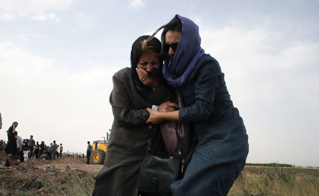 Relatives of passengers on board the crashed Tupolev Tu-154 passenger plane cry at the crash site in Qazvin, northwestern Iran, July 16, 2009. [Ahmad Halabisaz/Xinhua]