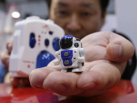 Japanese toymaker TOMY Company's Motomasa Kuge displays the company's world smallest class infrared light controlled biped walking robot 'ROBO-Q' at the International Tokyo Toy Show 2009 in Tokyo July 16, 2009. [Xinhua/Reuters]