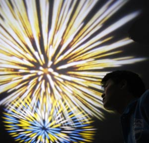 A staff of Sega Toys looks up at the ceiling during a demonstration of the company's new fireworks pattern projector called 'Uchiagehanabi' at the International Tokyo Toy Show 2009 in Tokyo July 16, 2009. The product, equipped with sound effects of the fireworks, will go on sale in Japan on August 1 for 15,540 yen ($166). [Xinhua/Reuters]