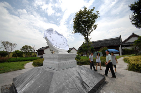 People watch the newly-installed equatorial sundial, measuring 1.5 meters in diameters, donated by the National Observatory to mark the spot for observation of the forthcoming 2009 total solar eclipse on the Yangtze Valley, believed to be the longest one visible in the century that is to betide on July 22, in Haining, east China's Zhejiang Province, July 15, 2009. [Wang Chaoying/Xinhua]