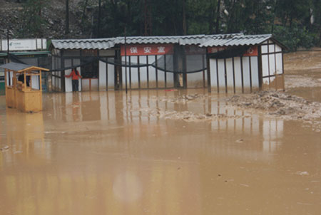 The movable houses at the Donghekou Earthquake Relics Park are flooded in Qingchuan County, southwest China's Sichuan Province, July 15, 2009. Heavy rains that began on Tuesday have killed one people and caused the other missing in Qingchuan County. [Xinhua]