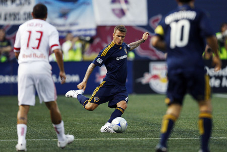 Los Angeles Galaxy's David Beckham of England (C) kicks the ball in front of teammate Landon Donovan and New York Red Bulls' Jorge Rojas (L) in the first half of their Major League Soccer game in East Rutherford, New Jersey, July 16, 2009. (Xinhua/Reuters Photo) 