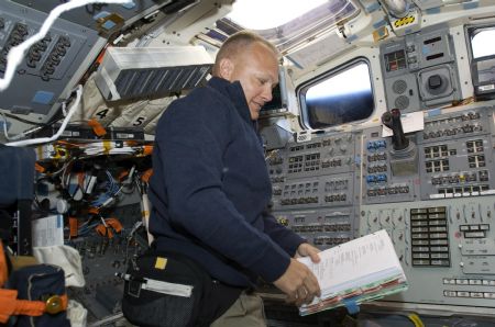 In this photo released by NASA, astronaut Doug Hurley, STS-127 pilot, reads a checklist on the aft flight deck of Space Shuttle Endeavour during flight day two activities July 16, 2009.[Xinhua/Reuters]