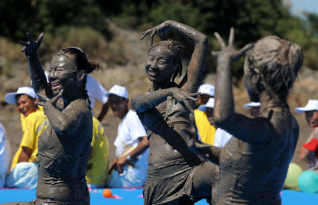 Tourists play with sea mud at a park in Xiushan Island, Daishan county, east China's Zhejiang province, Friday, July 17, 2009. [Xinhua]