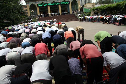 Hundreds of Muslims kneel down at the square and read Koran after imam in the Yanghang Mosque during the Friday prayer on July 17, 2009. [Photo from CRIENGLISH.com] 