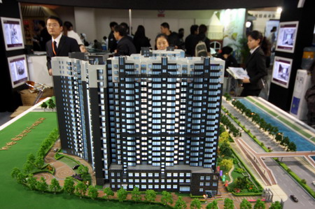 People look at a building model at an expo in Beijing. Beijing's commercial real estate market will remain under downward pressure, according to industry observers. [Asianewsphoto]