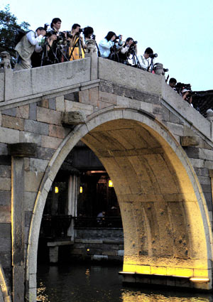 Tourists take pictures at Wuzhen, an ancient town of eastern China's Zhejiang Province, on July 18,