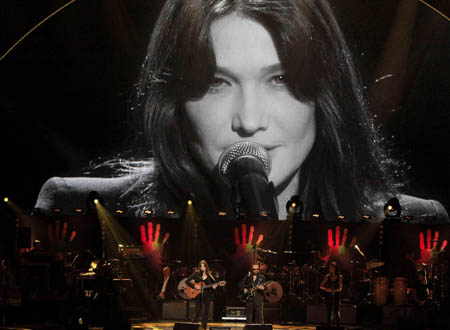 Carla Bruni-Sarkozy performs with Dave Stewart (R) as her image is projected on a screen, at The Mandela Day concert at Radio City Music Hall in New York July 18, 2009.