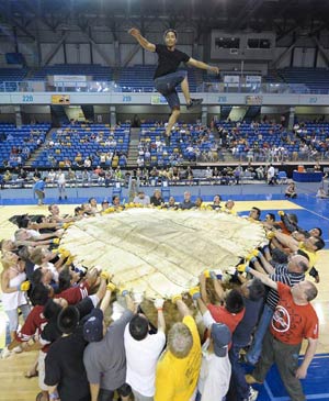 A man jumps up during the Blanket Toss competition in the 2009 World Eskimo-Indian Olympics held in Fairbanks, Alaska of the United States, July 18, 2009. The Blanket Toss competition originated from the Eskimo's celebration after hunting walrus. The competitor is tossed by the walrus leather held by 44 people.