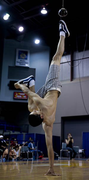 A competitor standing on one hand kicks the ball with one foot during the Alaskan High Kick contest in the 2009 World Eskimo-Indian Olympics held in Fairbanks, Alaska of the United States, July 18, 2009. This contest originated from the Eskimo's celebration after whaling. A good competitor can reach above 2.15m.