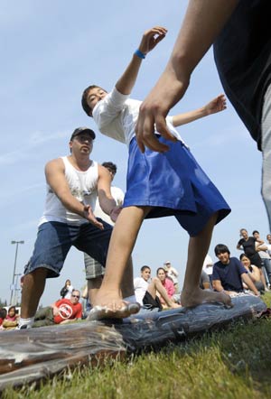 A young man balances himself on a greased pole during the Greased Pole Walk contest in the 2009 World Eskimo-Indian Olympics held in Fairbanks, Alaska of the United States, July 18, 2009. The contest tests the sense of balance of an Eskimo sailor walking on the slippery deck.