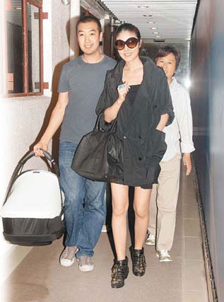 Kelly Chen (M) and Alex Lau walk out of a hospital in Hong Kong on Wendesday, July 15, 2009.