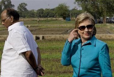 Indian Agriculture Minister Sharad Pawar, left, walks as U.S. Secretary of State Hillary Rodham Clinton, right, looks on during a visit to the Indian Agricultural Research Institute in New Delhi, India, Sunday, July 19, 2009.[Manish Swarup/AP Photo] 