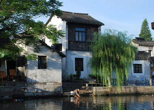 A woman washes clothes in a river on Sunday morning, July 19, 2009, in Xitang, a water town located in Eastern China's Zhejiang Province.[Photo: CRIENGLISH.com]