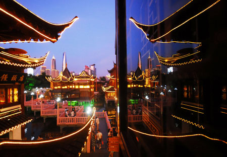  People spend the summer night on the Jiuqu Bridge in Yuyuan of Shanghai, east China, July 20, 2009. A month-long summer leisure festival was opened in Yuyuan, a famous garden in Shanghai on Junly 18. The festival provides a favorable place for local residents to spent hot summer nights with lamp shows and folk culture shows. (Xinhua)