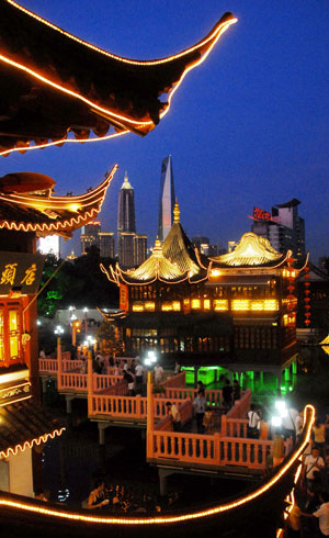 People spend the summer night on the Jiuqu Bridge in Yuyuan of Shanghai, east China, July 20, 2009. A month-long summer leisure festival was opened in Yuyuan, a famous garden in Shanghai on Junly 18. The festival provides a favorable place for local residents to spent hot summer nights with lamp shows and folk culture shows. (Xinhua)