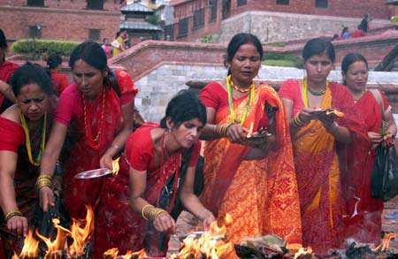 Nepalese Hindu women light lamp while worshiping Lord Shiva, the god of destruction, at the Pashupati temple in Kathmandu, capital of Nepal on July 20, 2009. Hundreds of Hindu women gathered at the Pashupati temple in Kathmandu, the world heritage site, on the first Shrawan Somvar (Monday) of the Nepalese calender Shrawan (July 15 - August 15) to offer holy water to Lord Shiva. Shrawan month is considered as the holiest month of the year and each Somvar (Monday) of this month known as Shrawan Somvar is special day in Shiva temples. Hindu women wear red attire as well as green and yellow bangles, pray for the long and prosperous life for their husbands. (Xinhua/Bimal Gautam)