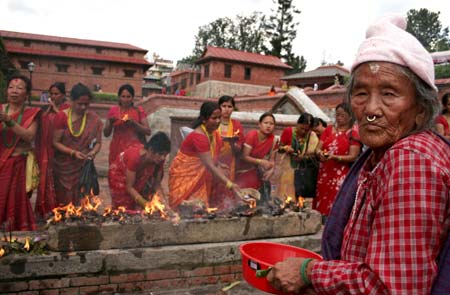 A Nepalese elderly woman looked as Hindu devotee offers prayers to the Hindu god Lord Shiva, the god of destruction, at the Pashupati temple in Kathmandu, capital of Nepal, July 20, 2009.