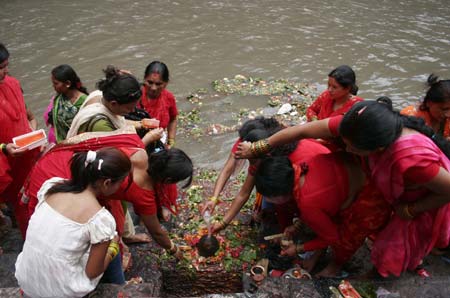 Nepalese Hindu women offer prayers to the Hindu god lord Shiva, the god of destruction, at the Pashupati temple in Kathmandu, capital of Nepal, July 20, 2009. 