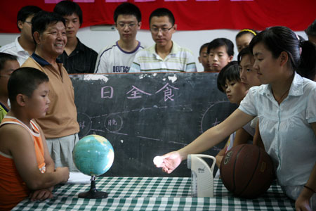 A group of Chinese kids learn the theory of total solar eclipse one day prior to the total solar eclipse observation at Taizhou City in east China's Jiangsu Province, July 21, 2009.(Xinhua/Gu Jun)