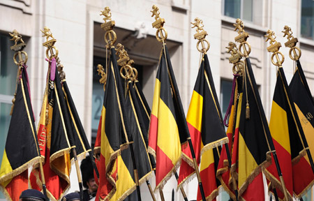 Soldiers hold up the national flags of Belgium attend the traditional military parade in central Brussels, capital of Belgium, July 21, 2009. Belgium celebrates its National Day and its 179th anniversary of independence on Tuesday. (Xinhua/Wu Wei)