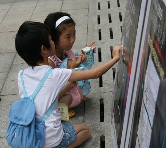 Two children look at a graphic explaining solar eclipses at Beijing Planetarium on the morning of July 22 2009. Some areas in south China witnessed a full solar eclipse on that day. But people in Beijing only saw a partial eclipse. 