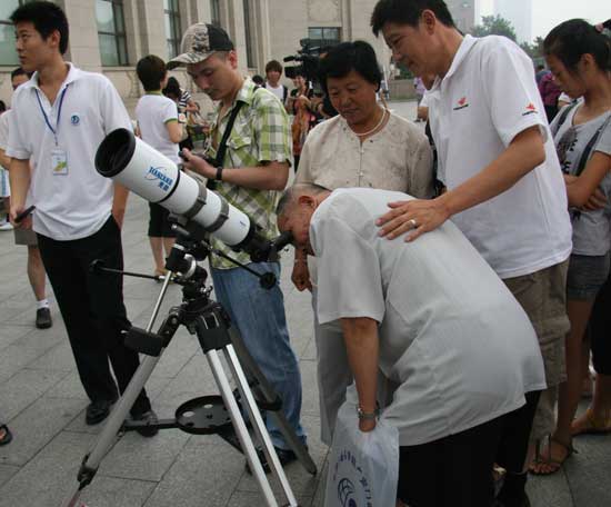 An old man watches a solar eclipse through a telescope at Beijing Planetarium on the morning of July 22 2009. Some areas in south China witnessed a full solar eclipse on that day. But people in Beijing only saw a partial eclipse. 