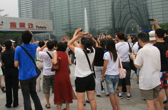 People watch a solar eclipse outside Beijing Planetarium on July 22 2009. Some areas in south China witnessed a full solar eclipse on that day. But people in Beijing only saw a partial eclipse. 