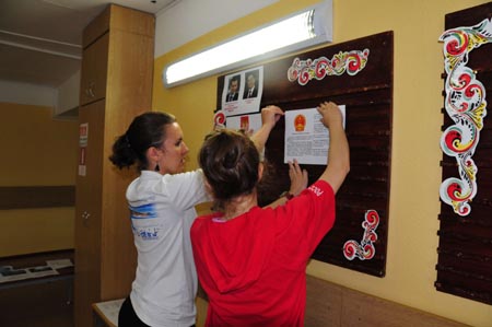 Staff members put up information about Russia and China at a children's center in preparation to welcome the students from China's earthquake-hit areas in Vladivostok, Russia, July 22, 2009. A total of 550 students from China's earthquake-hit areas will start a three-week relaxation trip at the center in Vladivostok on July 23. (Xinhua/Lou Chen)