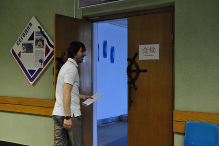 A staff member walks by a sign written in both Russian and Chinese at a children's center in preparation to welcome the students from China's earthquake-hit areas in Vladivostok, Russia, July 22, 2009. A total of 550 students from China's earthquake-hit areas will start a three-week relaxation trip at the center in Vladivostok on July 23. (Xinhua/Lou Chen) 