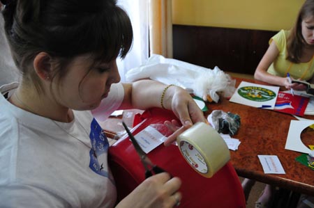 Staff members make signs written in both Russian and Chinese at a children's center in preparation to welcome the students from China's earthquake-hit areas in Vladivostok, Russia, July 22, 2009. A total of 550 students from China's earthquake-hit areas will start a three-week relaxation trip at the center in Vladivostok on July 23. (Xinhua/Lou Chen)