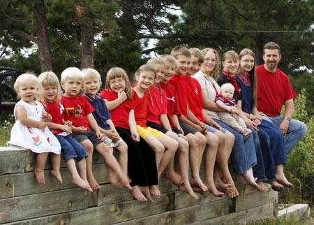 The Jeub family poses outside their home in Monument, Colorado July 19, 2009. (R-L) Father Chris, Cynthia, Lydia, mother Wendy holding Zechariah, Isaiah, Micah, Noah, Tabitha, Keilah, Hannah, Josiah, Joshua, Havilah and Priscialla.