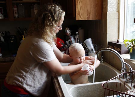 Wendy Jeub bathes her daughter Priscilla in the kitchen sink in their home in Monument, Colorado July 19, 2009. Quiverfull believers Wendy and Chris Jeub have 15 children and would be happy to have more if God wills it they say. 