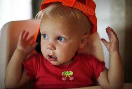 Priscilla Jeub, 1, looks on after putting on a hunting hat she found in the family home in Monument, Colorado July 17, 2009.