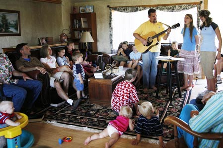 Chris Jeub (with guitar) sings as he leads a Sunday morning worship for family and friends in his living room in Monument, Colorado home July 19, 2009. Quiverfull believers Wendy and Chris Jeub have 15 children and would be happy to have more if God wills it they say.