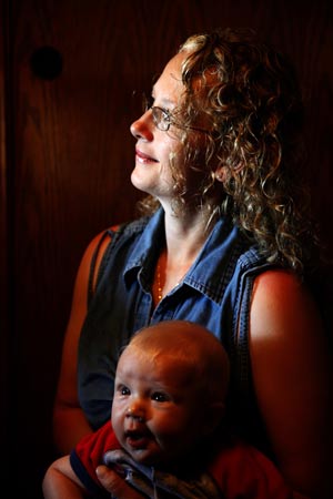 Wendy Jeub holds 4-month-old son Zechariah while watching a daughter open birthday presents in Monument, Colorado July 17, 2009.