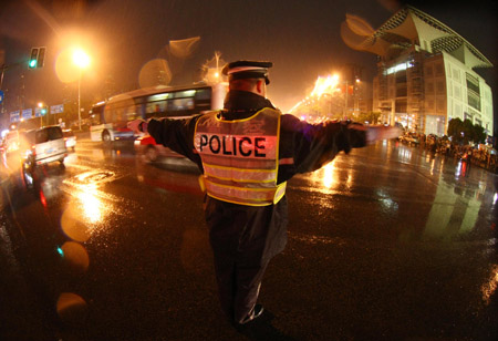 A traffic policeman works on the illuminated road when full solar eclipse occurred over east China's Shanghai, July 22, 2009. As full solar eclipse occured, the city illumination of main roads and airports were switched on for safe traffic.(Xinhua Photo)