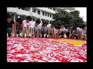 Students paint a national flag of 60 square meters with their hands ahead of the 60th anniversary of the founding of the PRC on July 21 in Hanshan County of Anhui Province. Many festivities are being planned for this year's National Day.(China.org.cn / CFP)