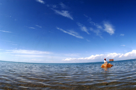 A tourist takes a picture of the Qinghai Lake in northwest China's Qinghai Province, July 21, 2009. As the boom season for tourism began, more and more tourists arrived here to enjoy the natural scenery. (Xinhua/Karma) 