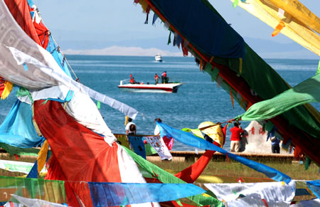 Tourists are seen beside the Qinghai Lake in northwest China's Qinghai Province, July 21, 2009. As the boom season for tourism began, more and more tourists arrived here to enjoy the natural scenery. (Xinhua/Karma) 