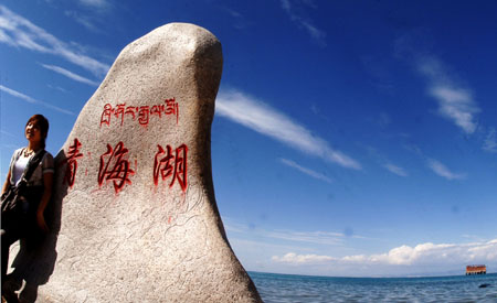 A tourist poses for a picture beside the Qinghai Lake in northwest China's Qinghai Province, July 21, 2009. As the boom season for tourism began, more and more tourists arrived here to enjoy the natural scenery. (Xinhua/Karma)
