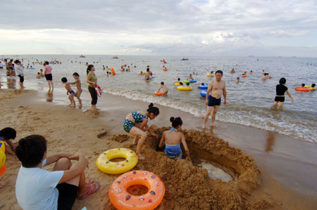 People amuse themselves on the beach in Haikou, capital of south China's Hainan Province, July 23, 2009. The Great Heat, or Dashu, in Chinese traditional lunar calendar, which means the hottest day in the summer, falls on July 23 this year. A large number of people in Haikou went to the beach to cool themselves down.