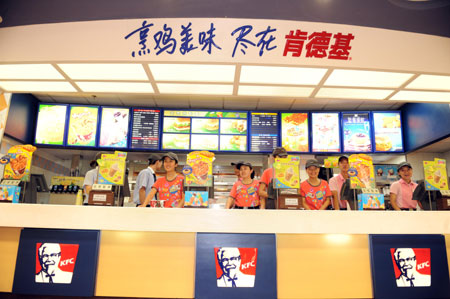 Staff members of a KFC store in the international bazar wait for customers in Urumqi, capital of northwest China's Xinjiang Uygur Autonomous Region, July 23, 2009. The KFC store in the international bazar, which was closed after the July 5 riot, was reopened on Thursday. (Xinhua/Sadat)