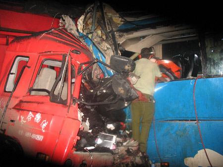 Photo taken on July 24, 2009 shows the scene of a car accident on an expressway in Qianxi County, southwest China's Guizhou Province. At least four people died and more than 40 others were injured after a bus-truck collision in wee hours on Friday in Qianxi County, according to local traffic authorities. (Xinhua) 