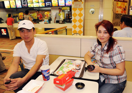 A couple from Uzbekistan eat at the KFC store in the international bazar in Urumqi, capital of northwest China's Xinjiang Uygur Autonomous Region, July 23, 2009. The KFC store in the international bazar, which was closed after the July 5 riot, was reopened on Thursday. (Xinhua/Sadat)