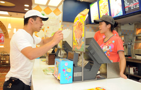 A man (L) from Uzbekistan orders at the KFC store in the international bazar in Urumqi, capital of northwest China's Xinjiang Uygur Autonomous Region, July 23, 2009. The KFC store in the international bazar, which was closed after the July 5 riot, was reopened on Thursday. (Xinhua/Sadat) 